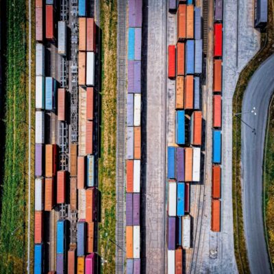 Widok z lotu ptaka na tory kolejowe i kontenery, gdzie ważne jest przestrzeganie prawo transportowe.