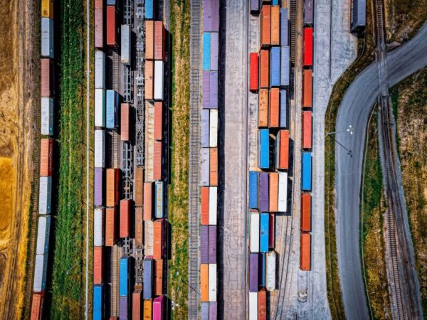 Widok z lotu ptaka na tory kolejowe i kontenery, gdzie ważne jest przestrzeganie prawo transportowe.
