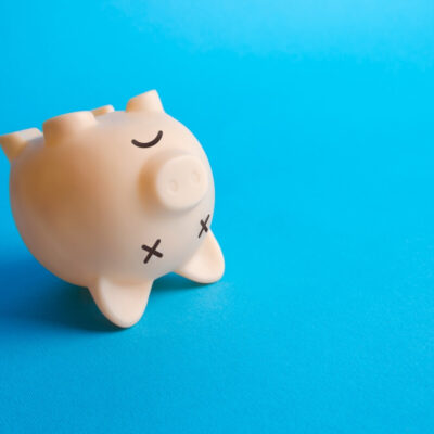 Skarbonka przewrócona na bok symbolizuje upadłość konsumencką.